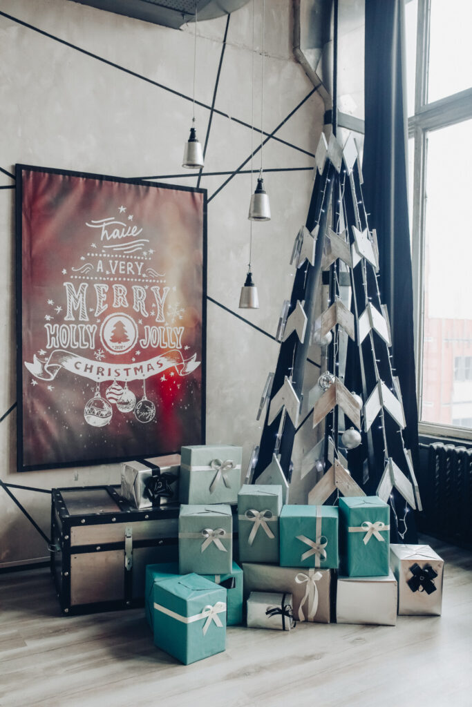 widok na pieknie zdobiony okragly stol z naturalna galazka jodly swieca dwoma fletami talerzami na tle klasycznej sofy w nowoczesnym mieszkaniu