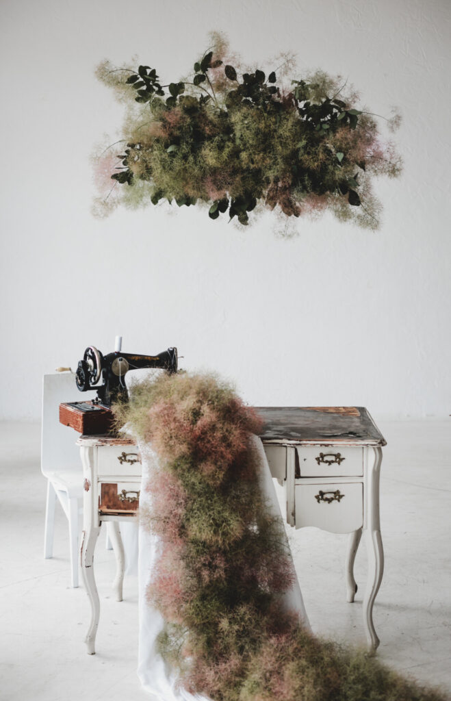 zielony dywan wisi na maszynie do szycia na stole